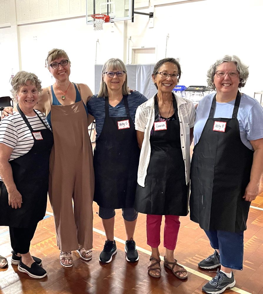 five women with aprons