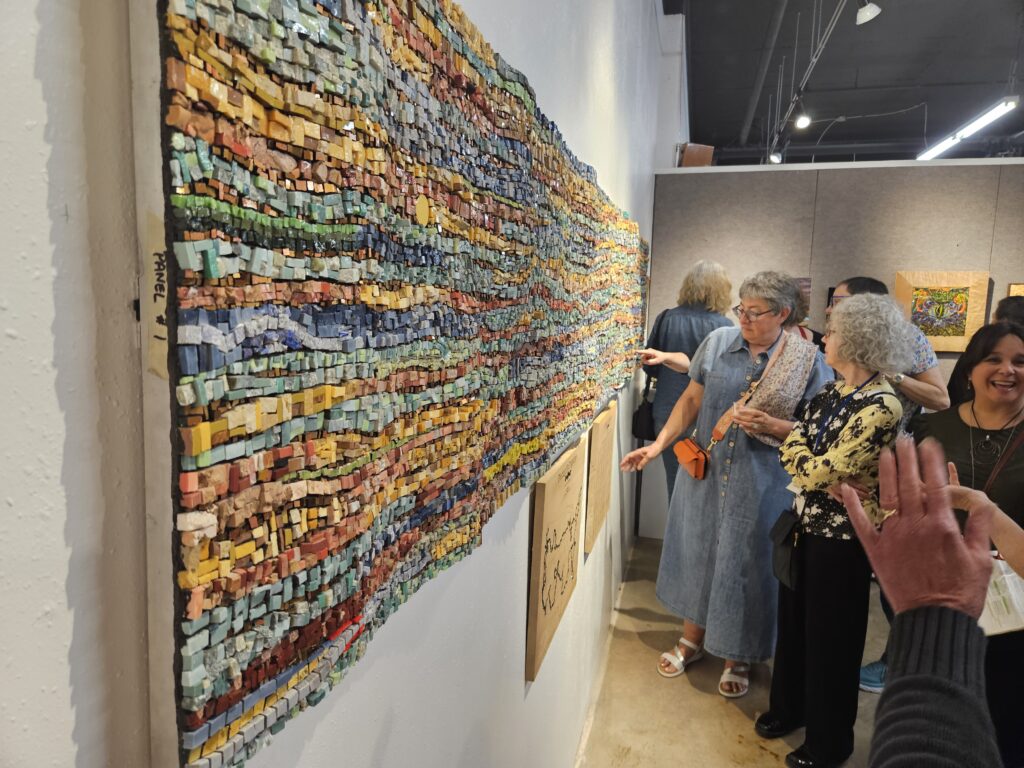 Mosaic by Kate Kerrigan "Piecing Us Together". She traveled the U.S. for 7 months during the pandemic and had people make small sections of mosaic that she then transformed into this giant tapestry.