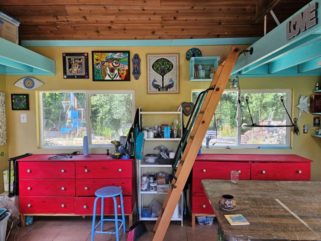 One wall of my studio, with art on the walls and dressers housing my supplies.